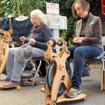 Janice Dotson of Port Angeles, left, and Karen Turner of Sequim, both members of the North Olympic Shuttle & Spindle Guild, pull yarn on spinning wheels as part of a demonstration of the art during the Pacific Northwest Fiber Exposition on Saturday at Vern Burton Community Center in Port Angeles. The three-day expo featured workshops, demonstrations and a marketplace of yarns and fibers. (Keith Thorpe/Peninsula Daily News)
