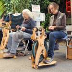 Janice Dotson of Port Angeles, left, and Karen Turner of Sequim, both members of the North Olympic Shuttle & Spindle Guild, pull yarn on spinning wheels as part of a demonstration of the art during the Pacific Northwest Fiber Exposition on Saturday at Vern Burton Community Center in Port Angeles. The three-day expo featured workshops, demonstrations and a marketplace of yarns and fibers. (Keith Thorpe/Peninsula Daily News)