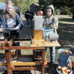 Michaela Christiansen, 14, left, and Pen DeBord, 14, both of Port Angeles, use a cider press to crush fresh apples into juice and pulp during Saturdays Applestock celebration in Sequim. The event, a benefit for several area charities, featured food, music, crafts and games in the orchard at Williams Manor B&B/Vacation Rental. Applestock 2023 beneficiaries were the Salvation Army Food Bank, Angel Tree Christmas, Coats for Kids and area food banks. (Keith Thorpe/Peninsula Daily News)