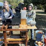 Michaela Christiansen, 14, left, and Pen DeBord, 14, both of Port Angeles, use a cider press to crush fresh apples into juice and pulp during Saturdays Applestock celebration in Sequim. The event, a benefit for several area charities, featured food, music, crafts and games in the orchard at Williams Manor B&B/Vacation Rental. Applestock 2023 beneficiaries were the Salvation Army Food Bank, Angel Tree Christmas, Coats for Kids and area food banks. (Keith Thorpe/Peninsula Daily News)