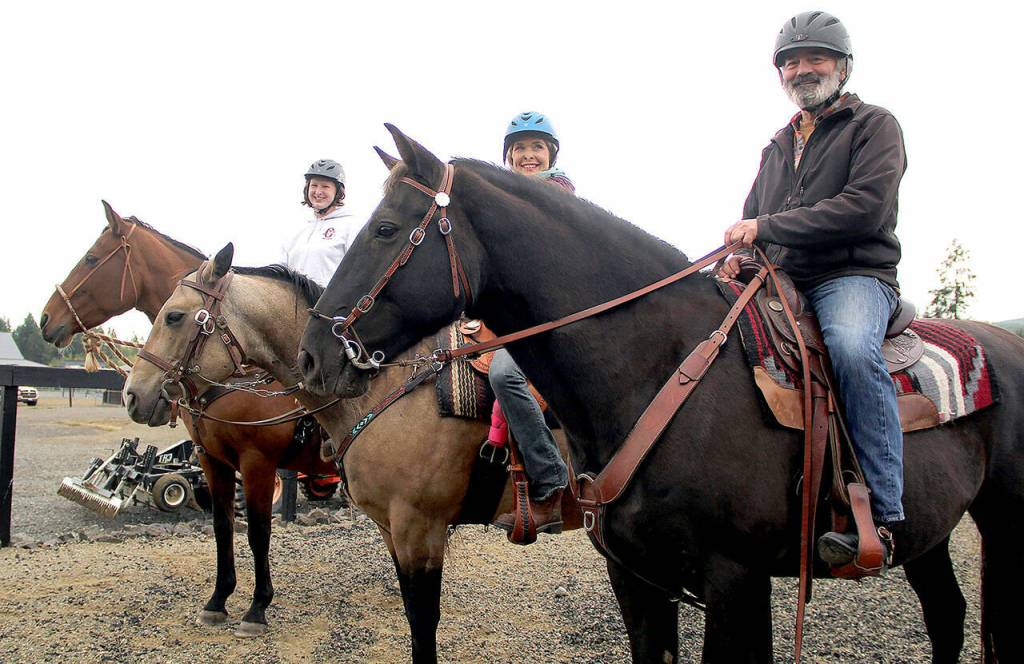 LaTasha Mason, left, Kate Tippets (horse trainer at OPEN) and Paul Eyestone wait for the next event to begin. (Karen Griffiths/for Peninsula Daily News)