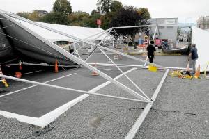 Crews from Bothel-based Grand Event Rentals assemble tent sections on Wednesday that will house parts of this weekends 22nd annual Dungeness Crab and Seafood Festival in downtown Port Angeles. The three-day event features a wide variety of seafood, music and other activities on the Port Angeles waterfront. (Keith Thorpe/Peninsula Daily News)