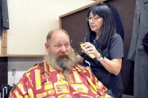 U.S. Navy veteran Brent Brant of Port Hadlock gets a haircut from Susan Gile, owner of Bennys Barbershop in Sequim, during Thursdays Port Angeles Stand Down at the Clallam County Fairgrounds. The event was designed to provide direct services and connect veterans to a variety of assistance organizations, as well as offer clothing, medical services and a meal. (Keith Thorpe/Peninsula Daily News)