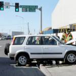 Port Angeles police and rescue workers assist the driver of a vehicle that crashed into a traffic light support pole at Marine Drive and the Tumwater Truck Route at abut 3:30 p.m. Thursday. No more information was available as of Friday. (KEITH THORPE/PENINSULA DAILY NEWS)