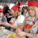 KEITH THORPE/PENINSULA DAILY NEWS
Dungeness Crab and Seafood Festival-goers, from left, Shannon Johnson and Krista Campbell, both of Victoria, and Tammi Donison of Saanich, B.C., enjoy crab dinners while adorned with crustacean hats during Friday's opening day. The three-day festival, which continues today and Sunday, features a variety of seafood, music and other activities in downtown Port Angeles.