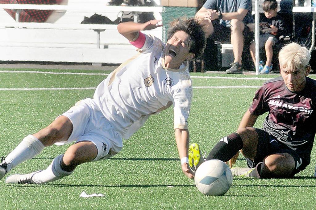 KEITH THORPE/PENINSULA DAILY NEWS
Peninsula's Tsubasa Abe, left, gets thrown off balance by a tackle by Whatcom's Christian Torres on Saturday at Peninsula College.