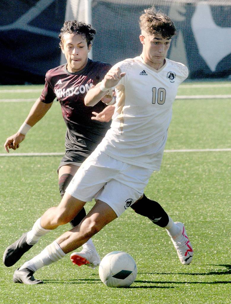 Peninsulas Nil Grau, front, works around the defense of Whatcoms Danny Rojas on Saturday at Peninsula College in Port Angeles. (Keith Thorpe/Peninsula Daily News)