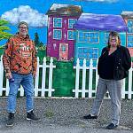 Artist Craig Robinson stands by a mural he painted at the Sequim Habitat Boutique Store in downtown Sequim in collaboration with his wife and Habitats chief executive officer Colleen Robinson. They said an angel wing mural has gotten a good response so far, too. (Matthew Nash/Olympic Peninsula News Group)