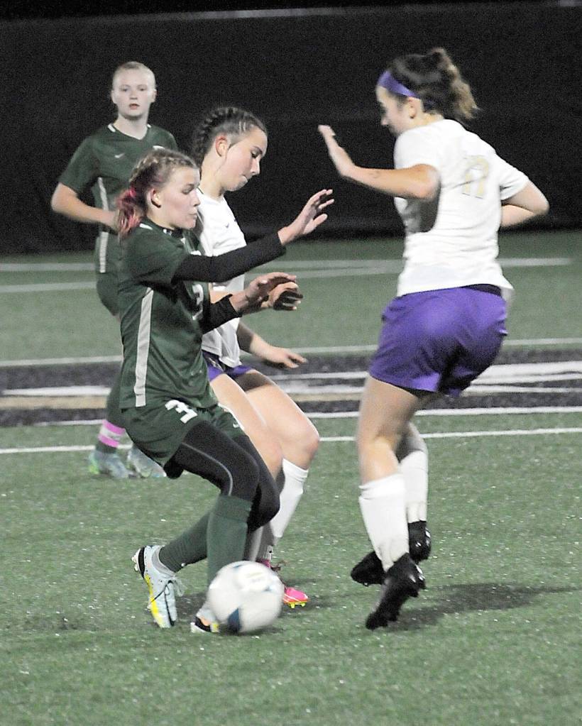 KEITH THORPE/PENINSULA DAILY NEWS Port Angeles Pyper Alton, left, is defended by Sequims Olive Bridge, center and Kaia Lestage, right, on Tuesday night at Peninsula College.