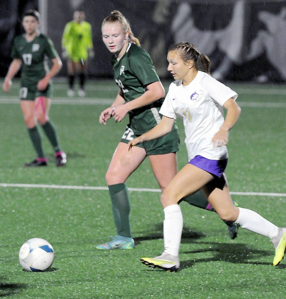 Sequims Kiley Winter, front, races for the ball with Port Angeles Paige Mason on Tuesday night at Peninsula College. (Keith Thorpe/Peninsula Daily News)