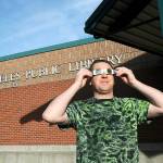 Jeff Clark, facilities technician for the North Olympic Library System, wears special glasses to observe Saturdays partial eclipse of the sun in front of the Port Angeles Public Library. The annular eclipse was visible as a ring of fire for a swath of watchers across Oregon to Texas and Mexico, was visible on the North Olympic Peninsula at about 80 percent with a large portion of the solar disc obscured by the Moon. (Keith Thorpe/Peninsula Daily News)