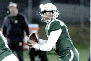 Port Angeles quarterback Parker Nickerson, right, looks to pass while receiving a block by teammate Coner Martin, left, during Fridays game against Bainbridge at Port Angeles Civic Field. (Keith Thorpe/Peninsula Daily News)