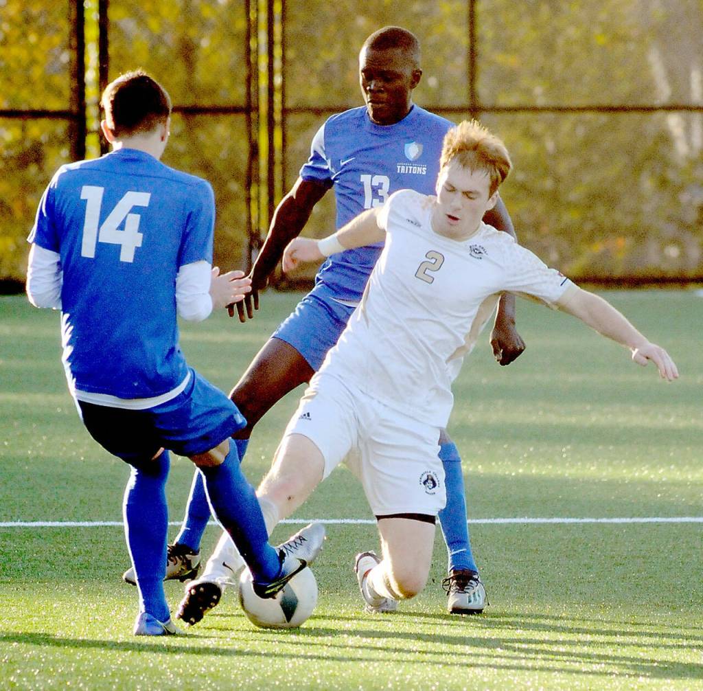Peninsulas Pip van der Ende, center, dribbles between Edmonds Lucas Totini, left, and Momodou Gigo on Wednesday in Port Angeles. (Keith Thorpe/Peninsula Daily News)