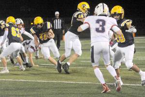 Forks Nate Dahlgren (40) finds a hole in the Titans defense as he runs for a touchdown Friday night under the lights of Spartan Stadium where Forks defeated Pe Ell/Willapa Valley 21-18. Blocking are Walker Wheeler (63), Brody Lausche (46) and DeAnthony Davila (20). (Lonnie Archibald/for Peninsula Daily News)