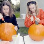 Armed with matching knives, Emma Briggance, 10, left, and Layla Newlon, 12, both of Port Angeles, prepare pumpkins for decorating during a pumpkin carving workshop on Saturday at the Port Angeles Fine Arts Center. Jack-o-lanterns created during the session were to be displayed in a pumpkin walk in the nearby Websters Woods Sculpture Park. (Keith Thorpe/Peninsula Daily News)
