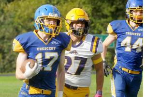 KEITH THORPE/PENINSULA DAILY NEWS
Crescent's Lukas Love, left, sprints for the end zone pursued by Concrete's Adam Culver, center, and teammate Carter Clifford on Saturday in Joyce.