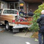 A two-vehicle wreck ended in a pickup driving into Caregivers Home Health at 622 E. Front St. early Tuesday afternoon, according to Port Angeles Police Sgt. Kevin Miller, pictured far right. The pickup, driven by Linda Turman of Port Angeles, was on the far right of the road when it switched to the left lane, which was occupied by a late model Ford Mustang, Miller said. The pickup hit the building. Turman was reported in satisfactory condition at Olympic Medical Center later in the day. The Mustang was damaged but did not crash into anything or block traffic. Turman was cited for improper lane use, Miller said. (Keith Thorpe/Peninsula Daily News)