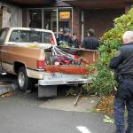 A two-vehicle wreck ended in a pickup driving into Caregivers Home Health at 622 E. Front St. early Tuesday afternoon, according to Port Angeles Police Sgt. Kevin Miller, pictured far right. The pickup, driven by Linda Turman of Port Angeles, was on the far right of the road when it switched to the left lane, which was occupied by a late model Ford Mustang, Miller said. The pickup hit the building. Turman was reported in satisfactory condition at Olympic Medical Center later in the day. The Mustang was damaged but did not crash into anything or block traffic. Turman was cited for improper lane use, Miller said. (Keith Thorpe/Peninsula Daily News)