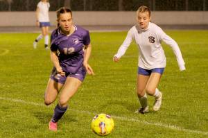 Sequims Olive Bridge, left, grabs possession of the ball and looks for a teammate in the first half of a 6-0 home win Tuesday over Bremerton. (Michael Dashiell/Olympic Peninsula News Group)