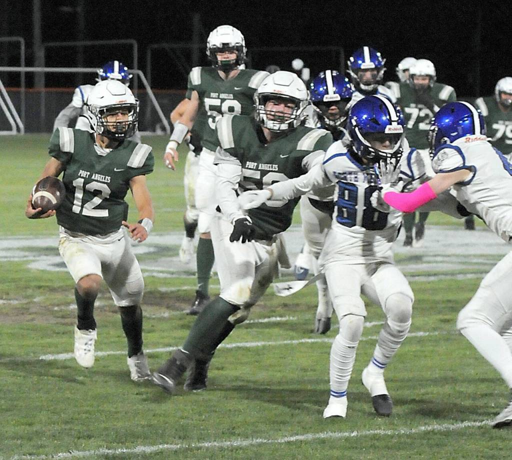 Port Angeles Kason Albaugh, left, receives a block from teammate Tanner Flores as the North Mason defense closes in during Fridays game at Port Angeles Civic Field. (KEITH THORPE/PENINSULA DAILY NEWS)