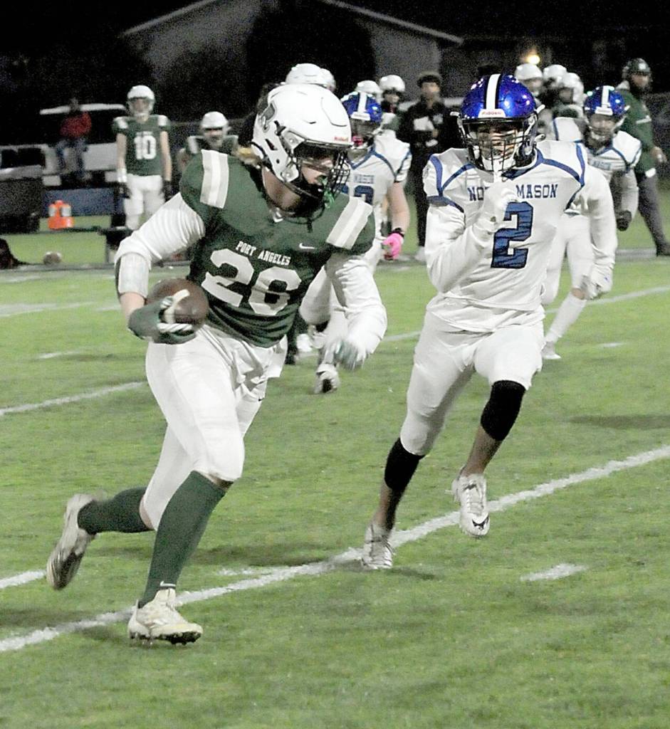 Port Angeles Landyn Jones sweeps past the pursuit of North Masons Trevon Simons on Friday night at Port Angeles Civic Field. (KEITH THORPE/PENINSULA DAILY NEWS)