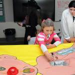 Sonnie Fountain, 8, of Sequim plays an oversized version of the Operation game under the direction of Sequim High School freshman Lillian Anderson during Saturdays Haunted Hallways holiday event at the school. Haunted Hallways featured a portion of the school set aside for a variety of Halloween games and attractions hosted by students as a benefit for the Sequim Food Bank. (Keith Thorpe/Peninsula Daily News)