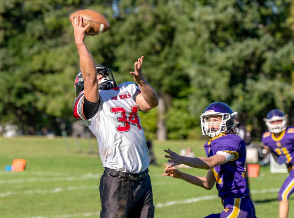 Steve Mullensky/for Peninsula Daily News
Quilcenes Tyler Buekes looks on as Neah Bays Tyler Swan makes a one-handed catch for a gain of 12 yards and a first down during a game in Quilcene on Saturday. Neah Bay won its sixth straight game 54-14.