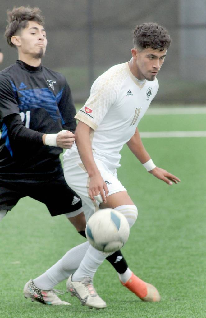 Peninsulas Manny Garcia, right, tries to get past the defense of Clarks Jared Armenta-Reyes on Saturday at Peninsula College. (Keith Thorpe/Peninsula Daily News)