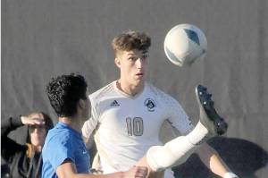 KEITH THORPE/PENINSULA DAILY NEWS
Peninsula's Nil Grau gives a high kick to keep the ball out of reach of Edmond's Enzo Buenaventura during a match at Wally Sigmar Field in October.