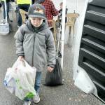 Brayden Shillington, 5, of Port Angeles carries a bag of donated food to a waiting van during Saturdays Food Drive conducted by employees of Lakeside Industries in the parking lot of Swains General Store in Port Angeles. By mid-afternoon, the participants had collected about 1,200 pounds of food and about $3,400 in monetary and matching donations to benefit area food banks. (Keith Thorpe/Peninsula Daily News)