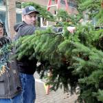 Port Angeles Parks and Recreation Department workers Eli Hammel, left, and Todd Shay string lights on the downtown Port Angeles Christmas tree at the Conrad Dyar Memorial Fountain on Tuesday in preparation for Saturdays lightning ceremony. (KEITH THORPE/PENINSULA DAILY NEWS)