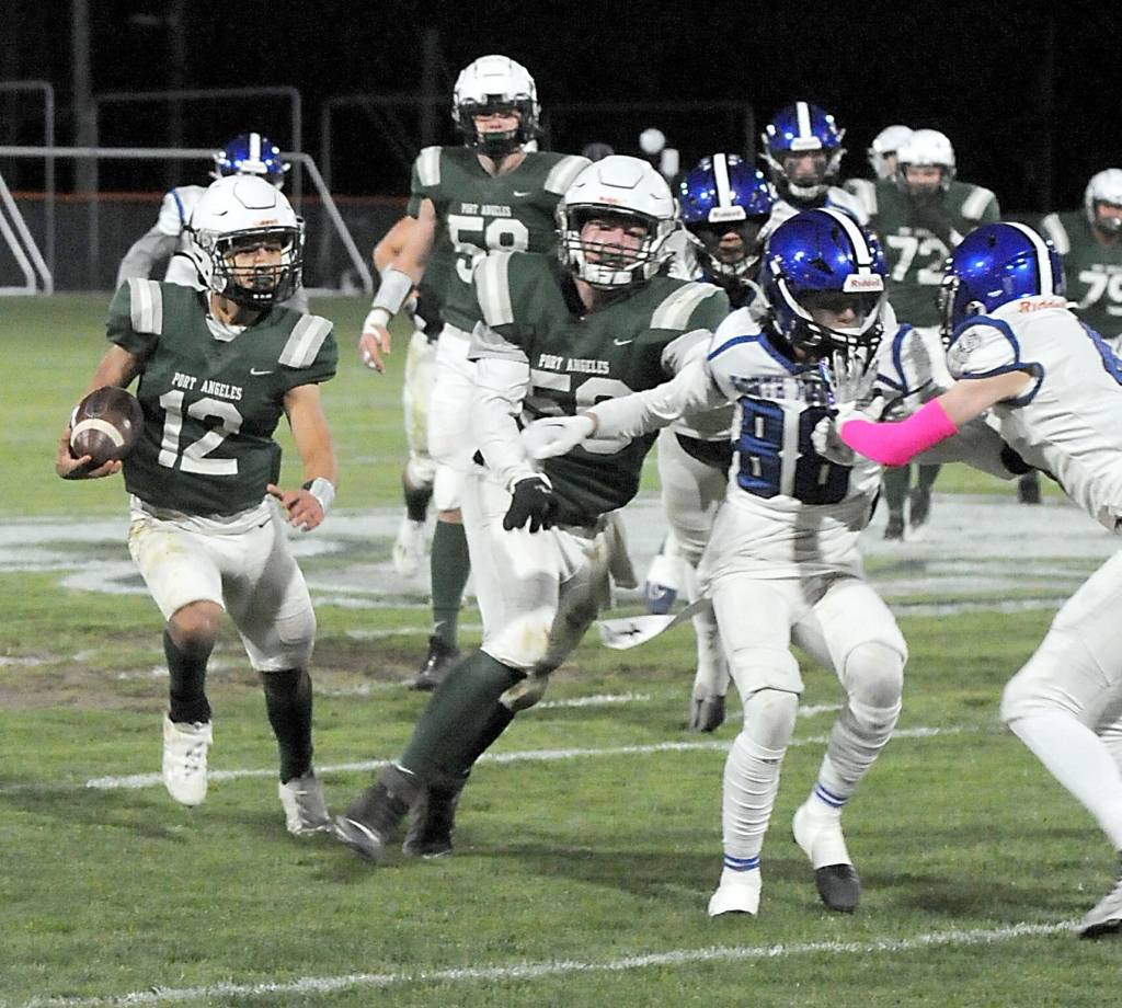 Port Angeles Kason Albaugh, left, receives a block from teammate Tanner Flores as the North Mason defense closes in a game this season at Port Angeles Civic Field. Flores made the Olympic League first team as an offensive lineman. (Keith Thorpe/Peninsula Daily News)