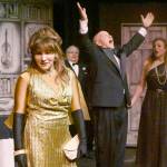 Acerbic magazine columnist Daria Chase (portrayed by Jamie Pauley) reveals that newly-married Simon Bright (Stephan Willms) has inherited a fortune in an early scene of The Games Afoot or Holmes for the Holidays. Looking on are host William Gillette (Joel Hoffman) and Brights new bride, Aggie Wheeler (Merrin Packer). (Michael Dashiell/Olympic Peninsula News Group)