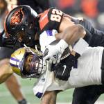 Washington running back Dillon Johnson is brought down by Oregon State linebacker Cory Stover (82) during the second half of an NCAA college football game Saturday, Nov. 18, 2023, in Corvallis, Ore. (Mark Ylen/The Associated Press)
