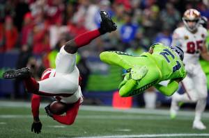 San Francisco 49ers wide receiver Brandon Aiyuk, left, defended by Seattle Seahawks cornerback Devon Witherspoon (21) catches a 28-yard pass for a touchdown during the second half of an NFL football game, Thursday, Nov. 23, 2023, in Seattle. (AP Photo/Lindsey Wasson)
