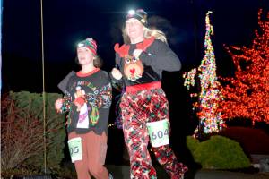 Sami Nolan, left, and Chelsea Pluard, both of Port Angeles, finish the 5K in the 2022 edition of the Jamestown SKlallam Glow Run in Blyn. The race returns Saturday afternoon and evening. (Run the Peninsula)