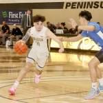 Peninsula Colleges Aiden Olmstead drives against the defense of South Puget Sound as Peninsula head coach Bryce Jacobson, background, watches the play. (Dave Logan/for Peninsula Daily News)