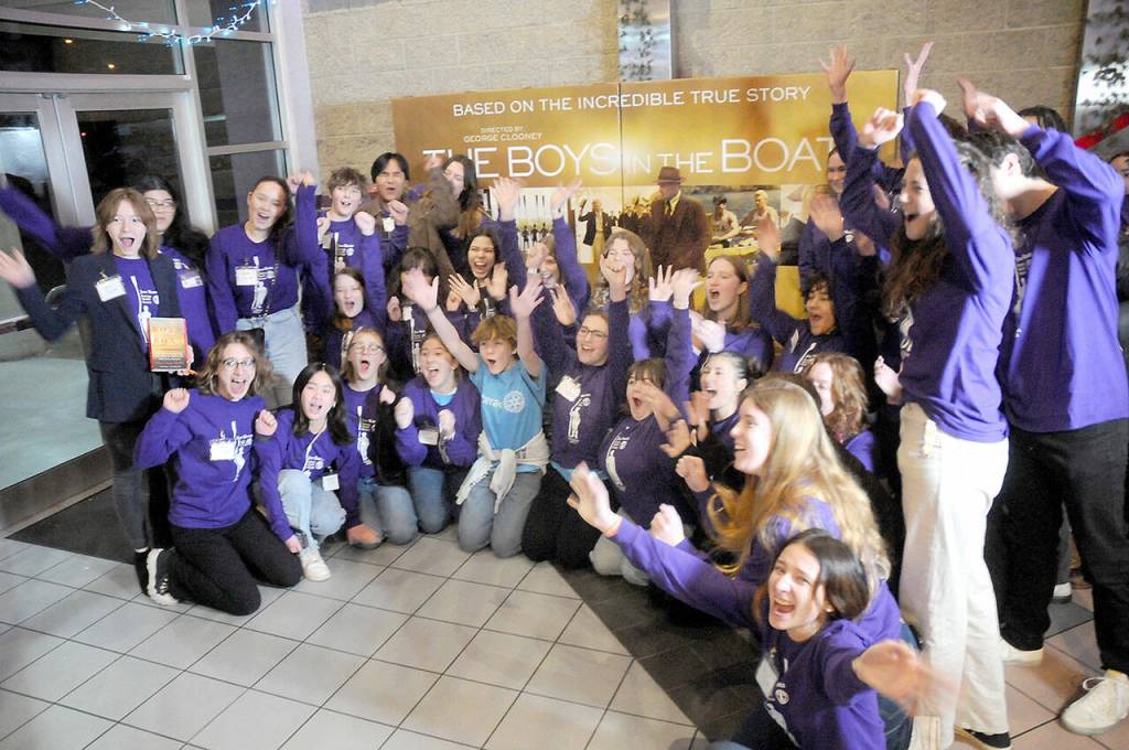 Members of the Sequim High School Interact Club respond to a prompt to show excitement for a television crew following Friday nights special screening of The Boys in the Boat at Deer Park Cinemas in Port Angeles. (Keith Thorpe/Peninsula Daily News)