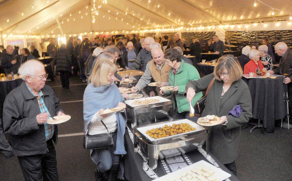 Guests at Friday nights gala benefiting the Joe Rantz Rotary Youth Fund go through a food serving line under an events tent at the Sequim Museum & Arts Center following a special showing of the film The Boys in the Boat in Port Angeles. (Keith Thorpe/Peninsula Daily News)