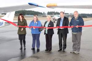 From left to right, Port of Port Angeles Commissioner Colleen McAleer, Ann Richart, the aviation director for the state Department of Transportation, Port Commissioner Connie Beauvais, Ryan Zulaul and Port Commissioner Steve Burke cut a ceremonial ribbon on Tuesday at Fairchild International Airport to celebrate the resurfacing of the runway. (Dave Logan/for Peninsula Daily News)