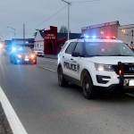 A parade honoring Ron Cameron, with nearly two dozen vehicles with lights flashing, heads east on First Street in Port Angeles. (DAVE LOGAN/FOR PENINSULA DAILY NEWS )