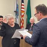 Sandy Long, left, was one of three Port Angeles School Board members sworn in by Clallam County Superior Court Judge Simon Barnhart on Dec. 14. Kirsten Williams and Stan Williams (no relation) also took the oath at the boards meeting. (Paula Hunt/Peninsula Daily News)