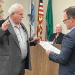 Stan Williams, left, was one of three Port Angeles School Board members sworn in by Clallam County Superior Court Judge Simon Barnhart on Dec. 14. Sandy Long and Kirsten Williams (no relation) also took the oath at the boards meeting. (Paula Hunt/Peninsula Daily News)