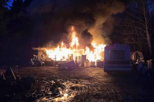 Clallam County Fire District 3 
Firefighters fight a house fire in the 900 block of Hooker Road on Wednesday. Law enforcement continued to seek a Sequim man suspected for the blaze on Thursday.