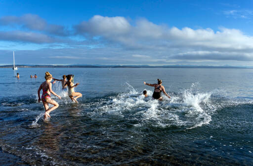 A hardy group of people run into the 47 degree waters of Port Townsend Bay at Fort Worden State Park on Monday in a Polar Bear plunge, a tradition on New Years Day. (Steve Mullensky/for Peninsula Daily News)