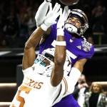 Washington cornerback Elijah Jackson (25) hits the ball before Texas wide receiver Adonai Mitchell (5) can catch it on the final play of the Sugar Bowl CFP NCAA semifinal college football game between Washington and Texas on Monday in New Orleans. Washington won 37-31. (AP Photo/Butch Dill)