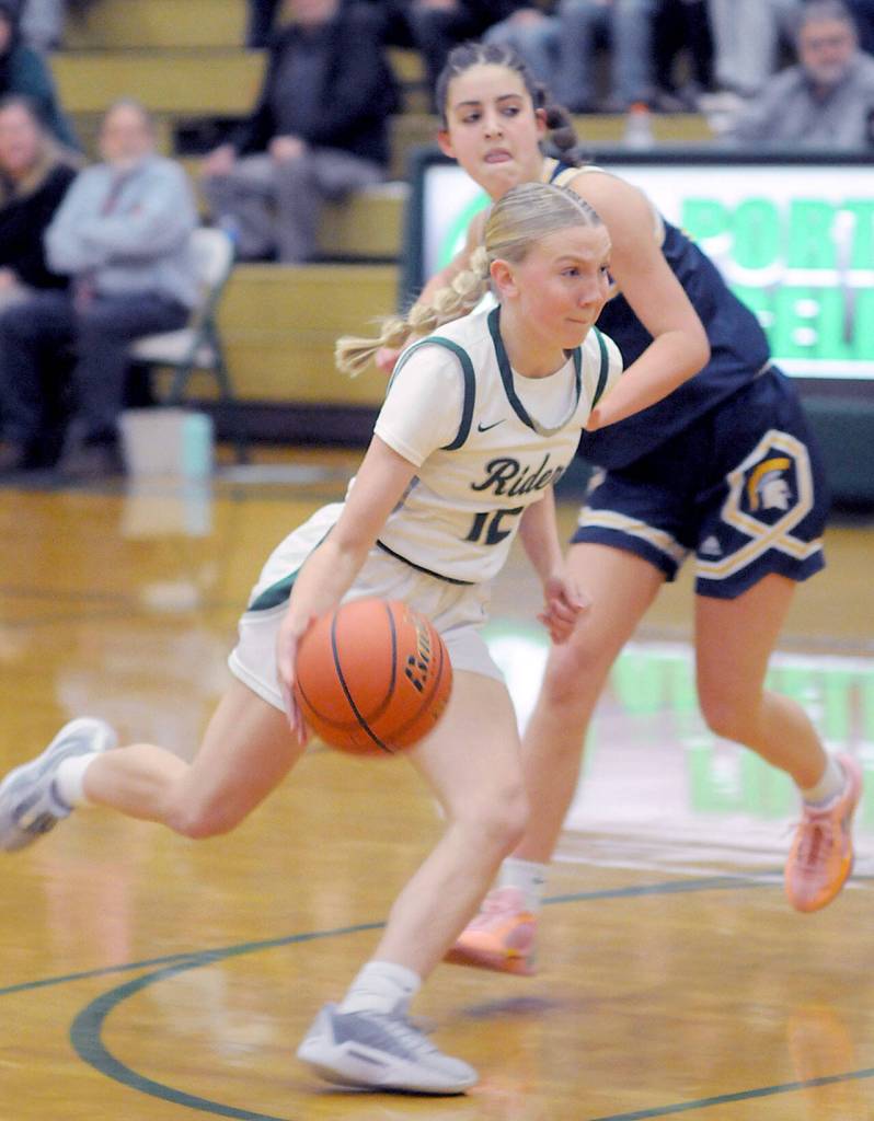 Port Angeles Izzy Felton, front, head for the lane past Bainbridges Elsa Drugge on Tuesday night at Port Angeles High School. (Keith Thorpe/Peninsula Daily News)