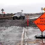 A car picks its way through a field of rocks and other debris pushed by wind-driven waves and high tides over Ediz Hook Road in Port Angeles on Tuesday. The city Public Works Department has closed the road. (Keith Thorpe/Peninsula Daily News)