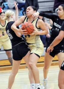 KEITH THORPE/PENINSULA DAILY NEWS Peninsulas Shania Moananu, center, squeezes between Whatcoms Ella Huyntington, left, and Alexa Rodriguez on Wednesday night at Peninsula College.