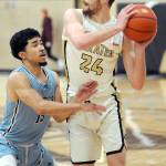 KEITH THORPE/PENINSULA DAILY NEWS Peninsulas Wyatt Dunning, a graduate of Port Angeles High School, holds off the defense of Whatcoms RaShawn Wilcox on Wednesday night at Peninsula College.